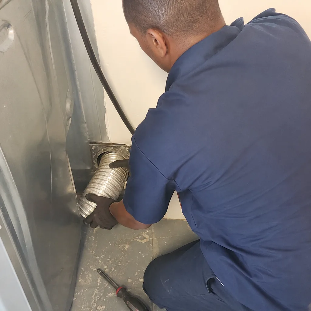 Technician installing flexible metal dryer vent hose for thorough cleaning service